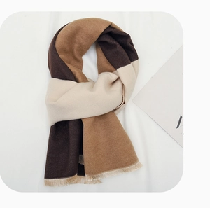 Detail of soft patchwork winter scarf for kids with fringes and geometric patterns