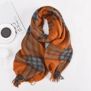 Orange and grey plaid cashmere-like scarf with fringe tassels on white textured background