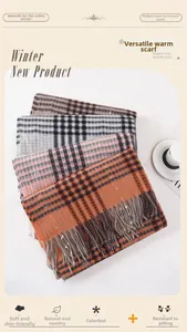 Detailed view of layered plaid scarves with tassels in soft knit cashmere-like texture