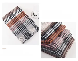 Detail of plaid scarf featuring mixed colors and soft tassel edges in a folded layout