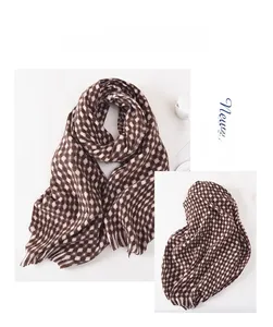 Close-up of brown and beige checkered scarf with soft tassels and knit texture