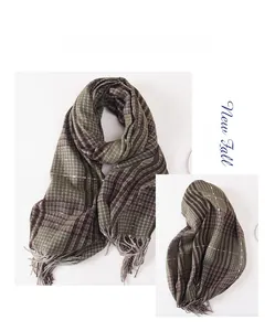 Detail of vintage plaid scarf with soft fringe in dark green and brown checkered pattern