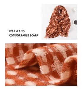 Detail of orange plaid scarf showing textured knit fabric and soft tassel fringe