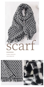 Macro detail of soft black and white plaid scarf fabric with elegant tassel fringe edges