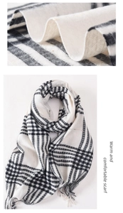 Detail of classic black and white plaid scarf fabric with fine fringe and soft texture