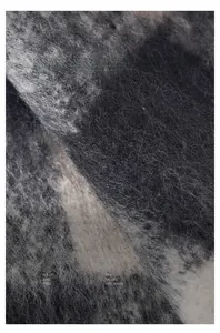 Close-up of thick brushed scarf featuring grey and beige color block plush texture
