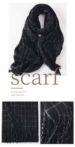 Close-up of classic black plaid scarf texture with soft tassels and warm fabric detail