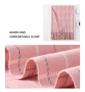 Detail of pink plaid cashmere-like scarf showing soft twill weave and tassel edges