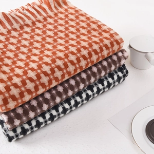 Thick checkered knit scarf with tassels in orange, pink, and black patterns