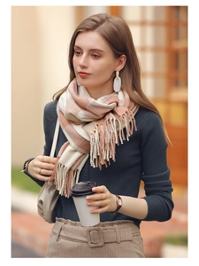 Close-up detail of soft checkered cashmere shawl with long fringe in pastel colors