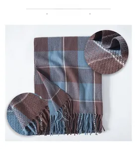Detailed view of checkered scarf with brown and blue plaid and long fringe tassels
