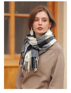 Detail of soft cashmere-feel scarf with grey plaid pattern and fringe tassels for winter