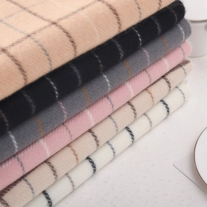 Stack of checkered cashmere scarves in khaki black and pink for winter warmth