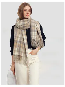 Detail shot of beige and white plaid tassel scarf in soft cashmere-like fabric on model