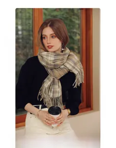 Detail shot of winter plaid scarf featuring soft cashmere texture and long fringe edges