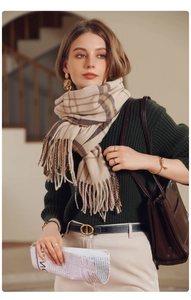 Detail of classic plaid scarf with soft tassels and premium beige cashmere texture