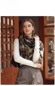 Detailed close-up of brown and black plaid scarf texture with soft fringe edge