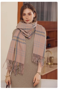 Detail of pink plaid scarf with fringe, featuring soft cashmere texture and cozy knit pattern