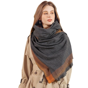 Grande écharpe à carreaux gris et noir avec rayures orange contrastées sur un mannequin