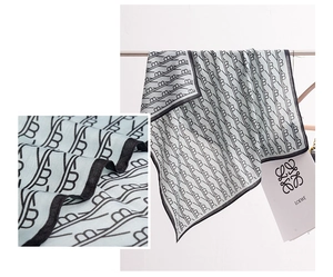 Detail of light blue silk scarf with interlocking geometric patterns and black rolled edges
