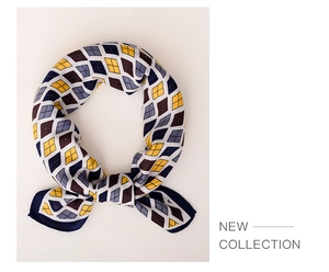 Detail of argyle pattern silk scarf tied in a knot showing mustard and navy colors