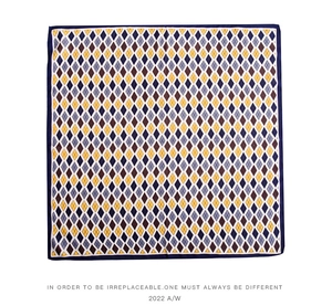 Flat lay of square silk scarf featuring navy and yellow argyle print on white background