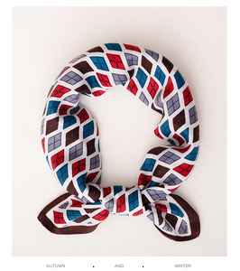 Detail of soft silk square scarf with classic red and blue argyle pattern and brown borders