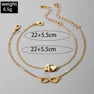 Detail of gold layered anklet set with initial A heart and infinity charm pendants