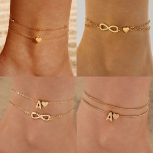 Layered gold anklet set with rhinestone heart and infinity charms for beach style