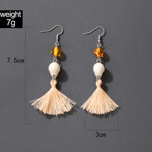 Détail de boucles d'oreilles tête de mort à pompons avec poids 7g et mesure de 7,5cm