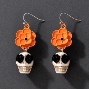 Boucles d'oreilles Halloween avec fleurs orange et crânes blancs aux yeux de roses