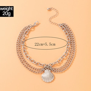 Detailed view of layered silver anklet featuring shell pendant and adjustable lobster clasp