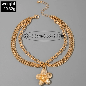 Detail of triple-layer gold anklet with flower pendant and adjustable ball chain