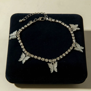 Detail of multi-layered butterfly charm anklet with micro-paved rhinestones and lobster clasp
