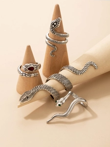 Macro detail of silver snake rings set with ruby and emerald gemstone eye accents