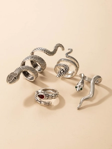 Close-up of four-piece vintage silver snake ring set with red and green gemstones