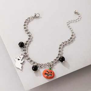 Macro view of Halloween charm bracelet with enamel ghost and orange pumpkin charms