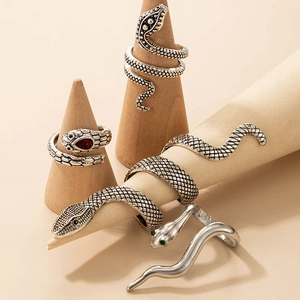 Exaggerated snake-shaped ring set with gemstones in vintage silver finish on wood stands
