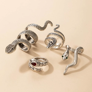 Vintage silver snake ring set with red gemstones and scales on a beige background