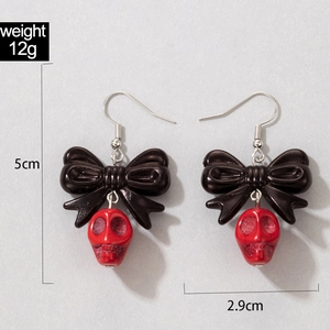 Détail des boucles d'oreilles crâne punk avec nœud noir et dimensions du produit