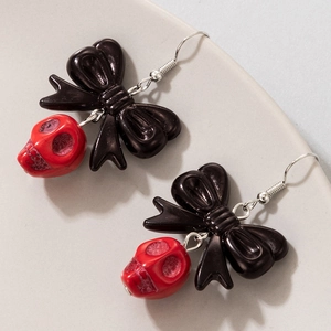 Détails de boucles d'oreilles gothiques avec nœuds noirs et pendentifs de crânes rouges