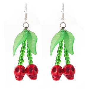 Détail de boucles d'oreilles crânes cerises rouges avec feuilles pour Halloween