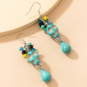 Détail macro de boucles d'oreilles bohèmes tête de mort avec perles colorées et turquoise