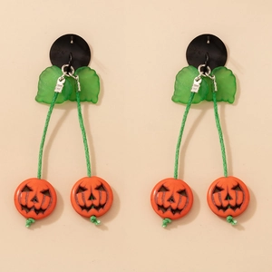 Détail des boucles d'oreilles citrouille d'Halloween avec breloques feuilles translucides