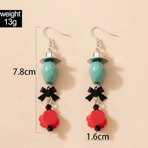 Détail de boucles d'oreilles gothiques avec perles turquoise et nœuds papillon noirs