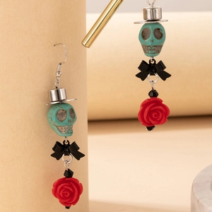 Détail des boucles d'oreilles gothiques avec crâne, nœud noir et pendentif rose rouge