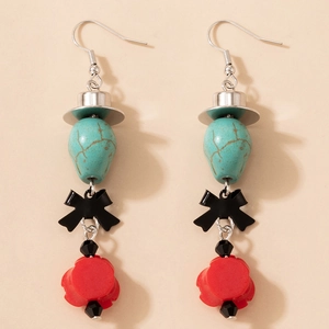 Détail de boucles d'oreilles gothiques avec nœud noir, rose rouge et perles turquoise