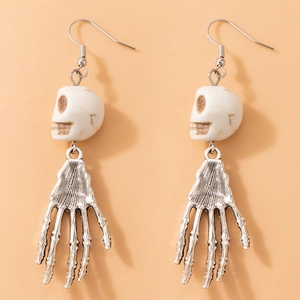 Vue macro de boucles d'oreilles tête de mort gothiques et main de squelette