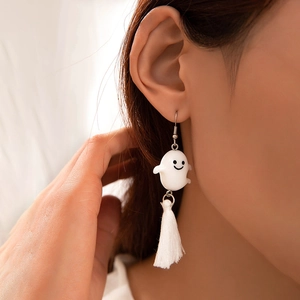 Détail de boucles d'oreilles fantômes blancs avec franges en soie portées par un mannequin
