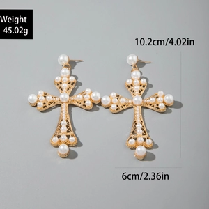 Vue détaillée de boucles d'oreilles croix dorées avec perles et dimensions précises